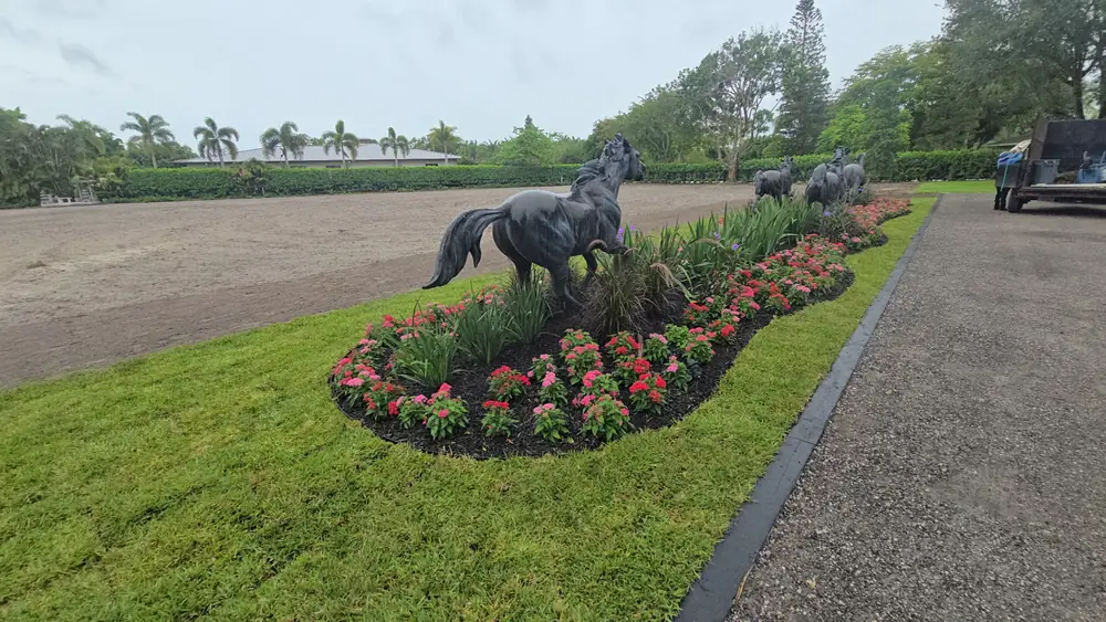 Bronze horse statues in a flower bed at an equestrian property